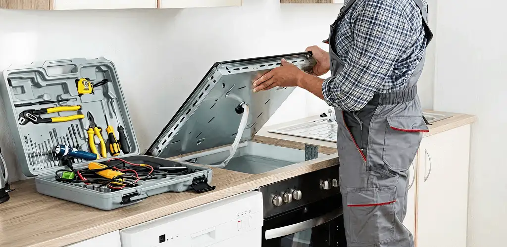 Handyman repairing a cooktop and checking wiring connections in Phoenix, AZ