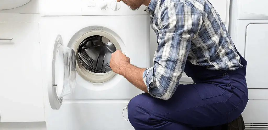 Handyman inspecting a dryer drum and internal parts for repair in Phoenix, AZ