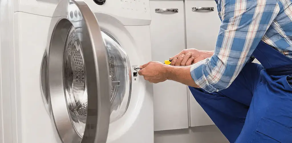 Handyman repairing a clothes dryer and checking electrical connections in Phoenix, AZ