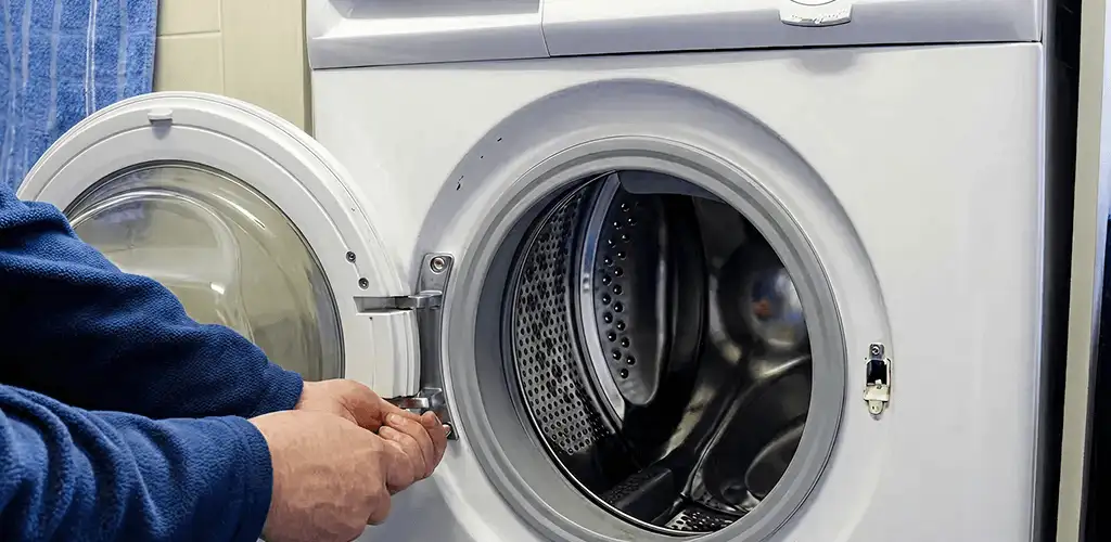 Washing machine repair handyman checking a front-load washer door and latch in Phoenix, AZ