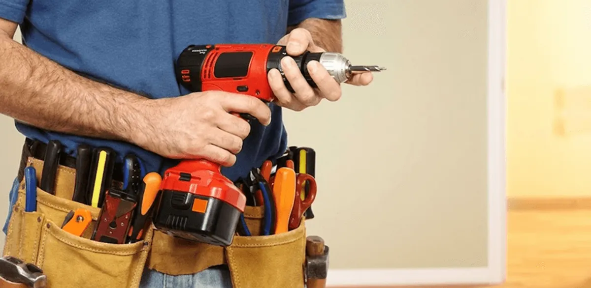 Handyman holding a power drill for home repairs and installations in Phoenix, AZ