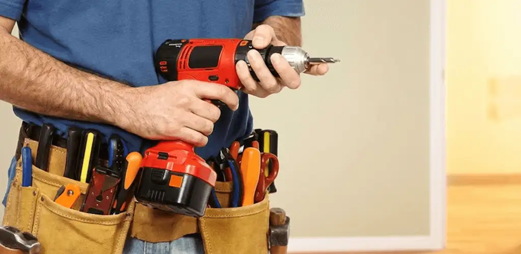 Handyman holding a power drill for home repairs and installations in Phoenix, AZ