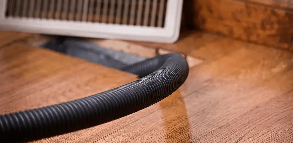 Air duct cleaning hose inserted into a floor vent for ductwork cleaning in Phoenix, AZ