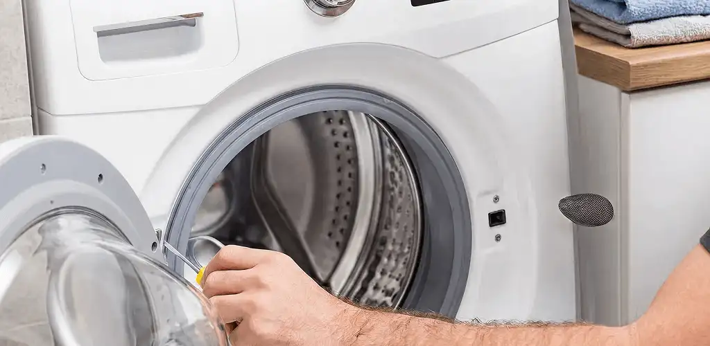 Handyman repairing a front-load washing machine and inspecting the drum in Phoenix, AZ