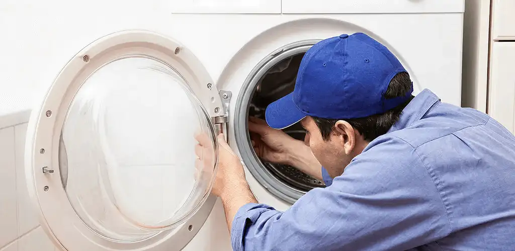 Washing machine repair handyman inspecting a front-load washer drum in Phoenix, AZ