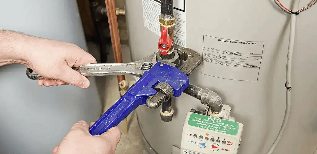 Water heater repair technician tightening the shutoff valve and supply line in Phoenix, AZ